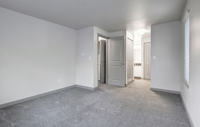 a bedroom with white walls and gray carpet