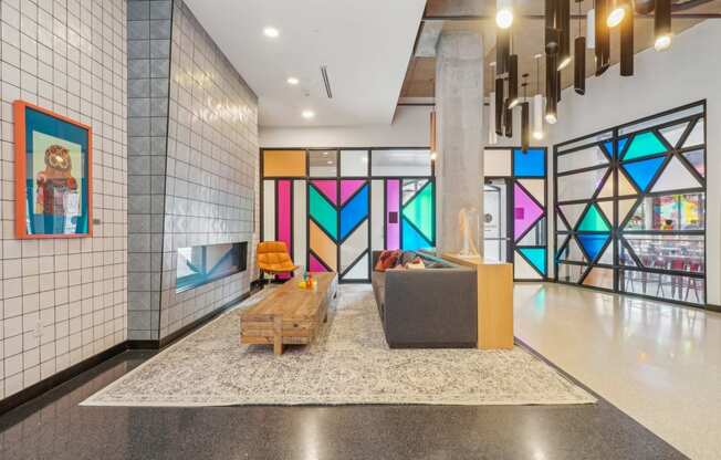 the lobby of a building with a colorful stained glass wall and a couch