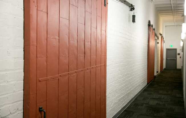 red warehouse doors and white walls in fix play hallway at Fix Play Lofts, Birmingham, AL, 35203