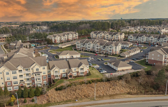 an aerial view of a large housing complex with a sunset in the background