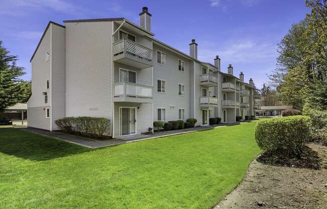 Exterior View of Apartments with Green Grassy Area at Campo Basso Apartment Homes, Lynnwood