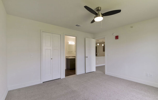 a room with a ceiling fan and a door to a bathroom at Chase Creek Apartment Homes, Huntsville, AL