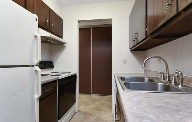 a kitchen with a sink and a refrigerator and a door. Roseville, MN Rosedale Estates