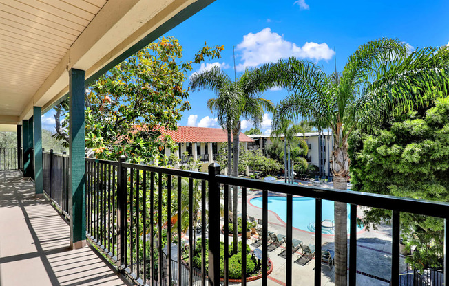 a balcony with a view of a pool and palm trees at Willow Tree Apartments, Torrance, CA, 90505