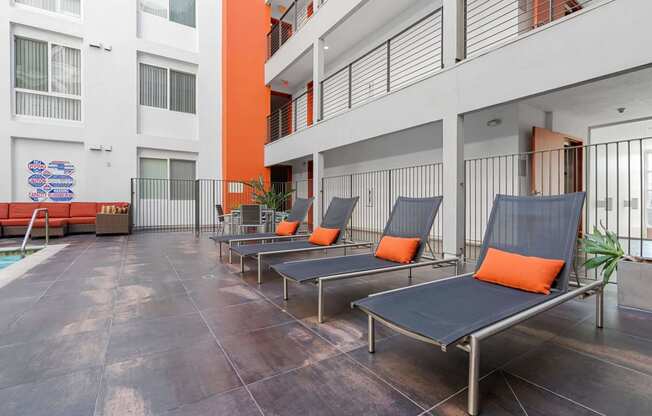 a row of lounge chairs in front of an apartment building