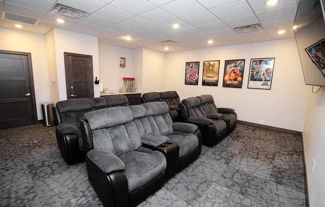 A row of black recliner chairs are lined up in a room.