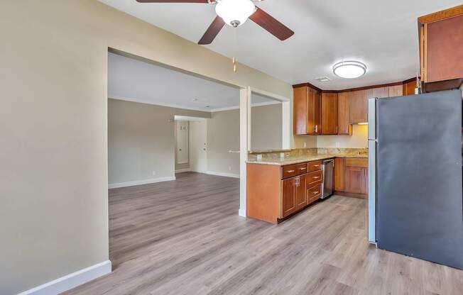A kitchen with wooden cabinets and a black refrigerator.