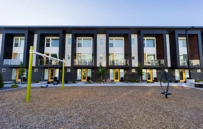 A modern building with a grey facade and yellow accents.