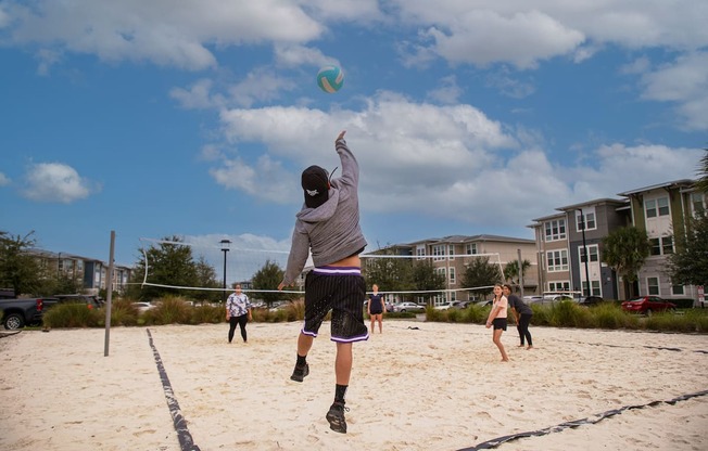 residents playing volleyball on sand court at Ariel