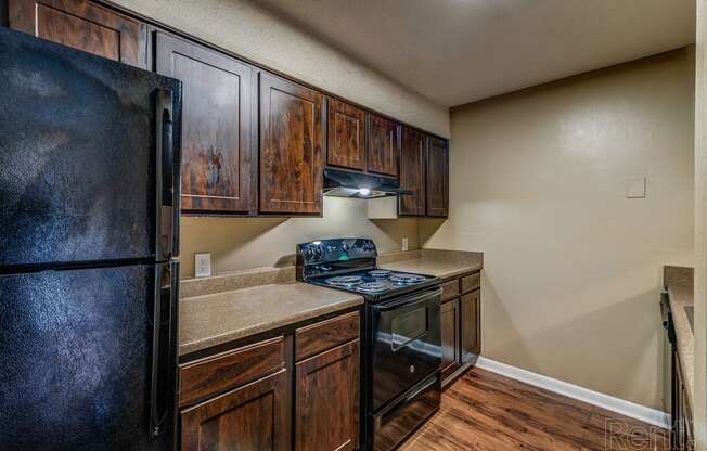 a kitchen with black appliances and wooden cabinets