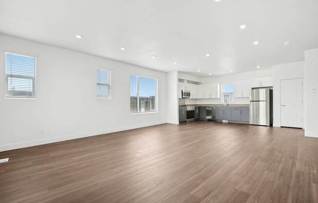 A spacious room with wooden flooring and white walls.