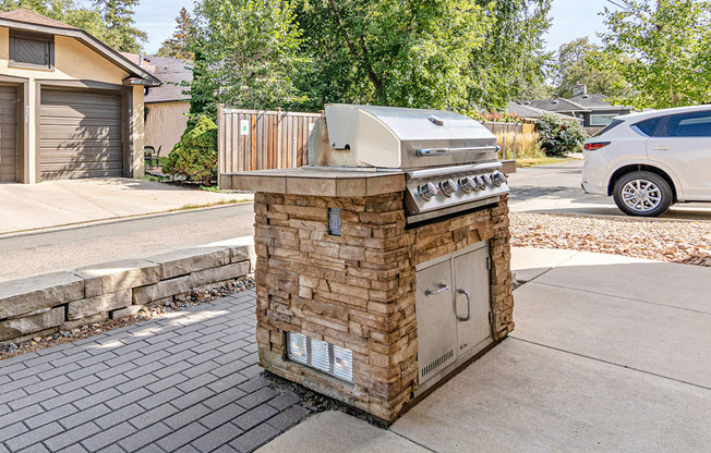 A small outdoor kitchen with a grill and sink.