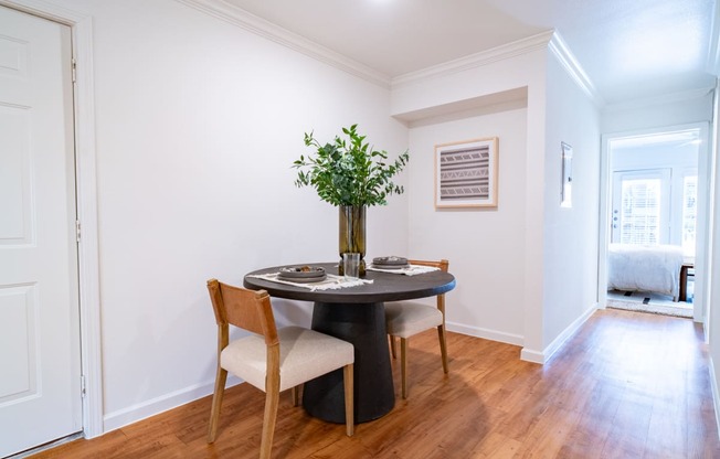 a dining room with white walls and a table and chairs