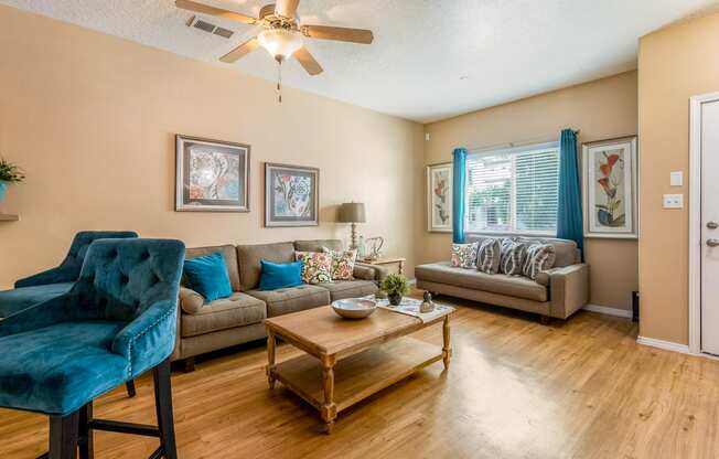 a living room with furniture and a ceiling fan