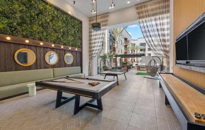 A room with a green wall and a pool table.