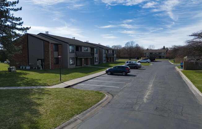 an apartment complex with cars parked in a parking lot