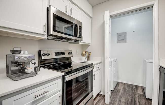 a kitchen with white cabinets and stainless steel appliances