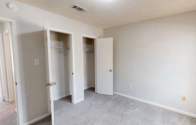 A room with three white closet doors.