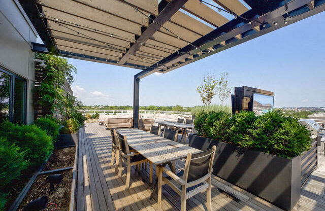 a wooden deck with a table and chairs under a roof