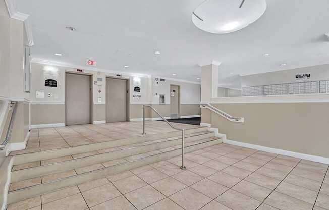 a large lobby with stairs and elevators in a building