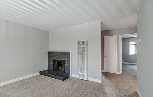 A room with a fireplace and a carpeted floor.