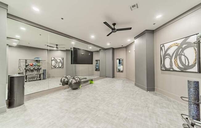 A spacious room with a ceiling fan and a mirror on the wall.