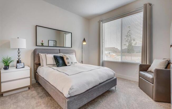 a bedroom with a bed and a window  at Affinity 56 Apartments in West Jordan, Utah