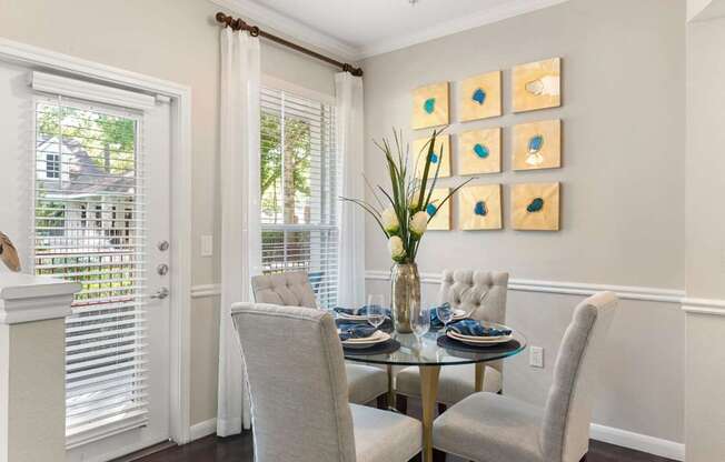A dining room with a glass table and chairs.