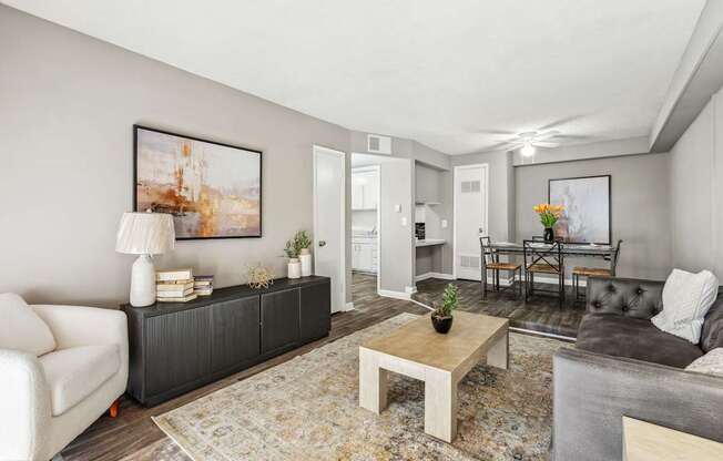 A living room with a white sofa, a coffee table, and a painting on the wall.