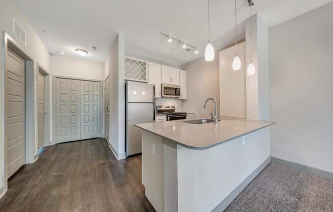 a renovated kitchen with white cabinets and a large counter top