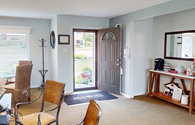 a living room with a door and a table and chairs