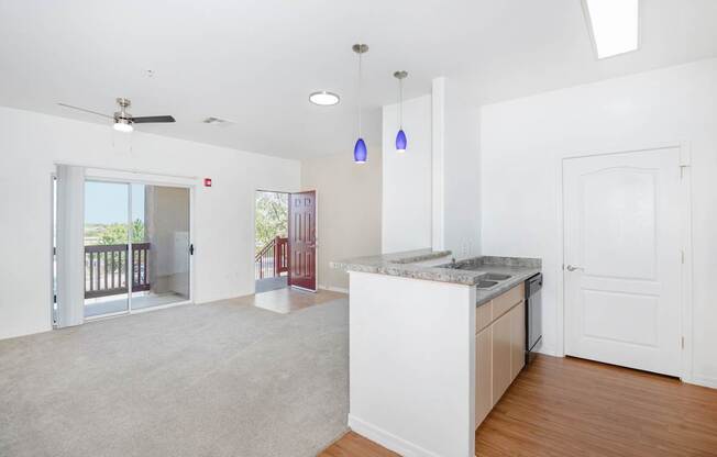 A kitchen with a white island and a ceiling fan.