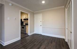 A kitchen area with a white door and a small fridge.