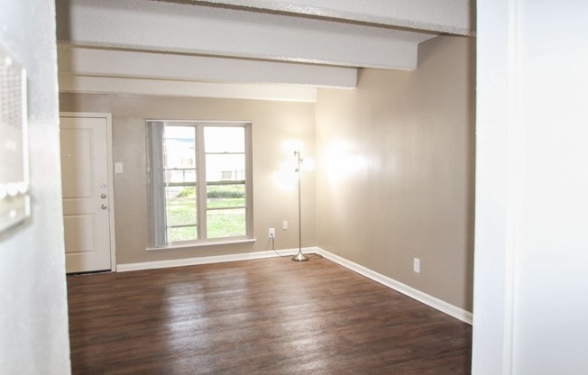 This is a photo of the living room from the kitchen of the 653 square foot 1 bedroom apartment at Harvard Square Apartments, in Dallas, TX.
