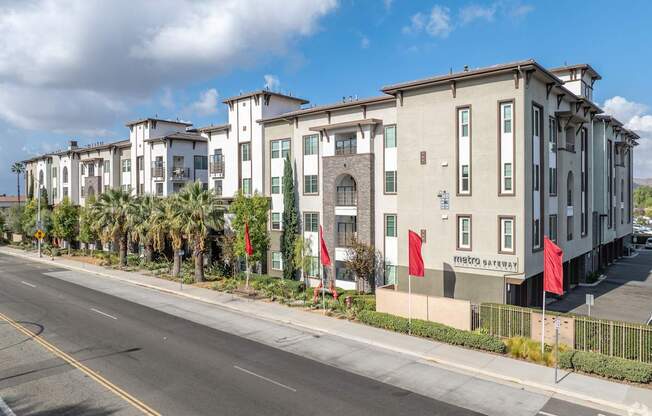 A row of modern townhouses with a street in front.