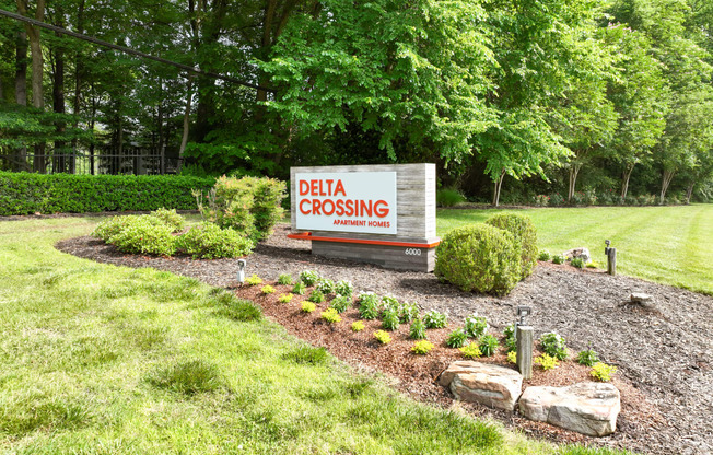 a sign for delta crossing in front of a garden