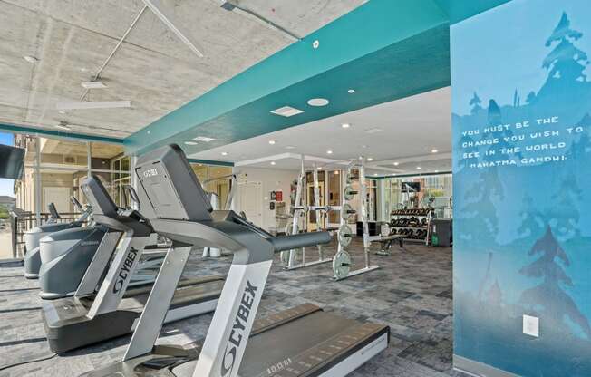 a gym with treadmills and other exercise equipment in the lobby of a building