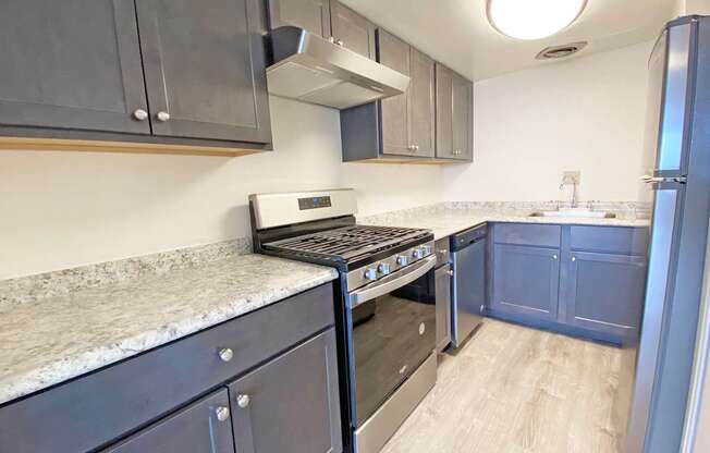 A kitchen with a stove top oven and a refrigerator.