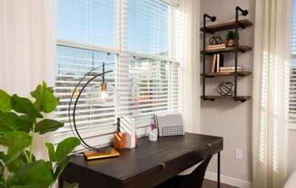 a home office with a large window and a wooden desk at 55 Fifty at Northwest Crossing, Houston Texas