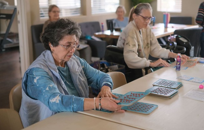 a group of women sitting at a table working on a board game