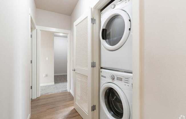 a washer and dryer in a laundry room with a white closet