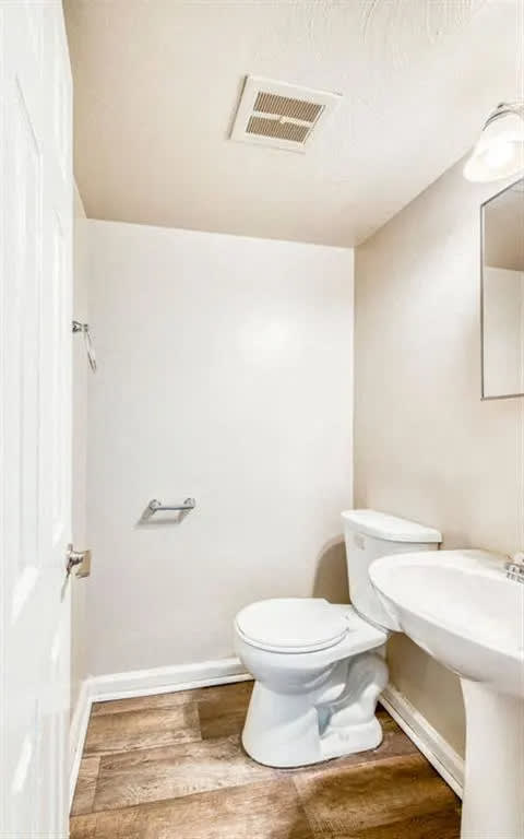 a bathroom with a toilet and a sink at Gates of West Bay, Norfolk Virginia