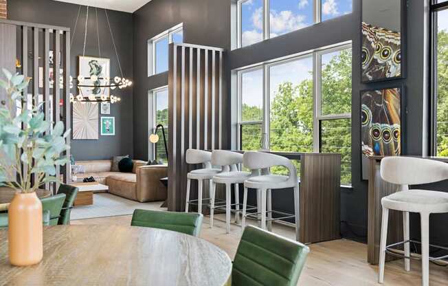 A modern living room with a wooden table and green chairs.