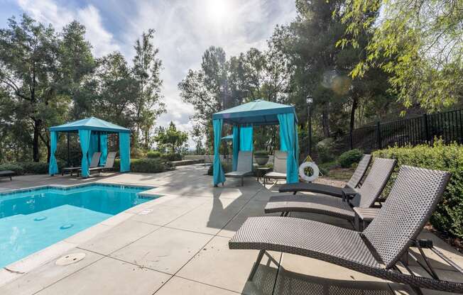 a swimming pool with chairs and umbrellas