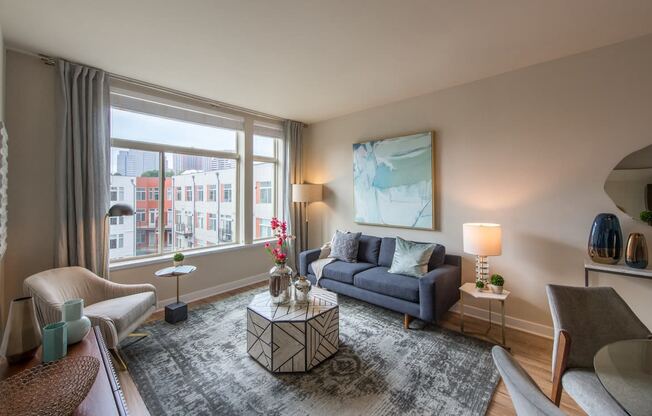 a living room with a large window and a blue couch