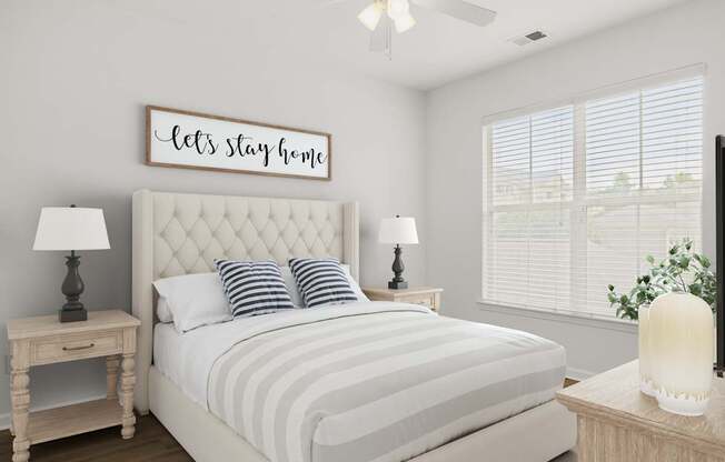 A bedroom with a bed, nightstands, and a ceiling fan.