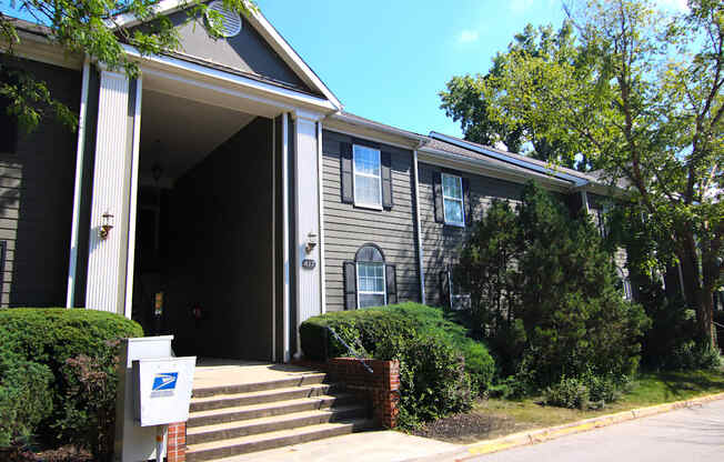 A grey house with a mailbox in front.
