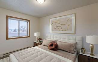 a bedroom with a bed and a window. Fargo, ND Crescent Park Apartments