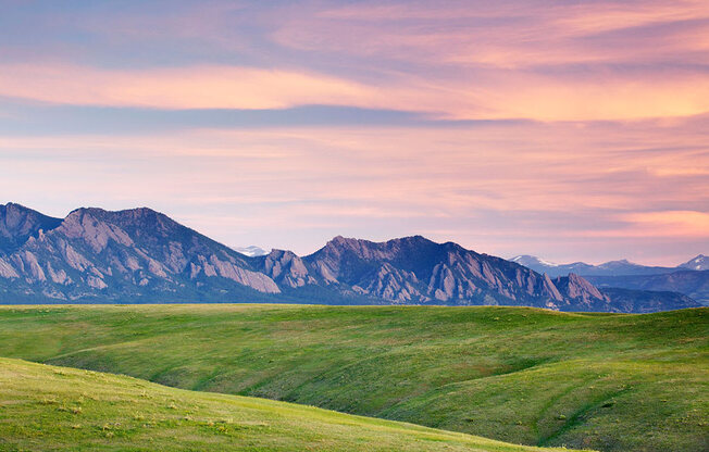 a grassy field with a mountain range in the background at Brownstones at Palisade Park Townhomes, Broomfield
