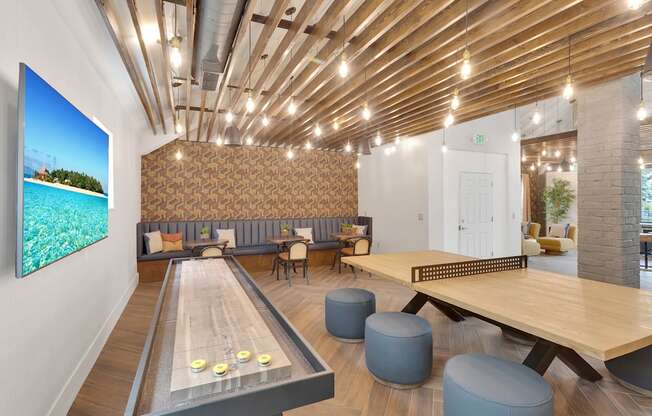 A room with a shiny wooden floor and a long table with a shiny wooden top.